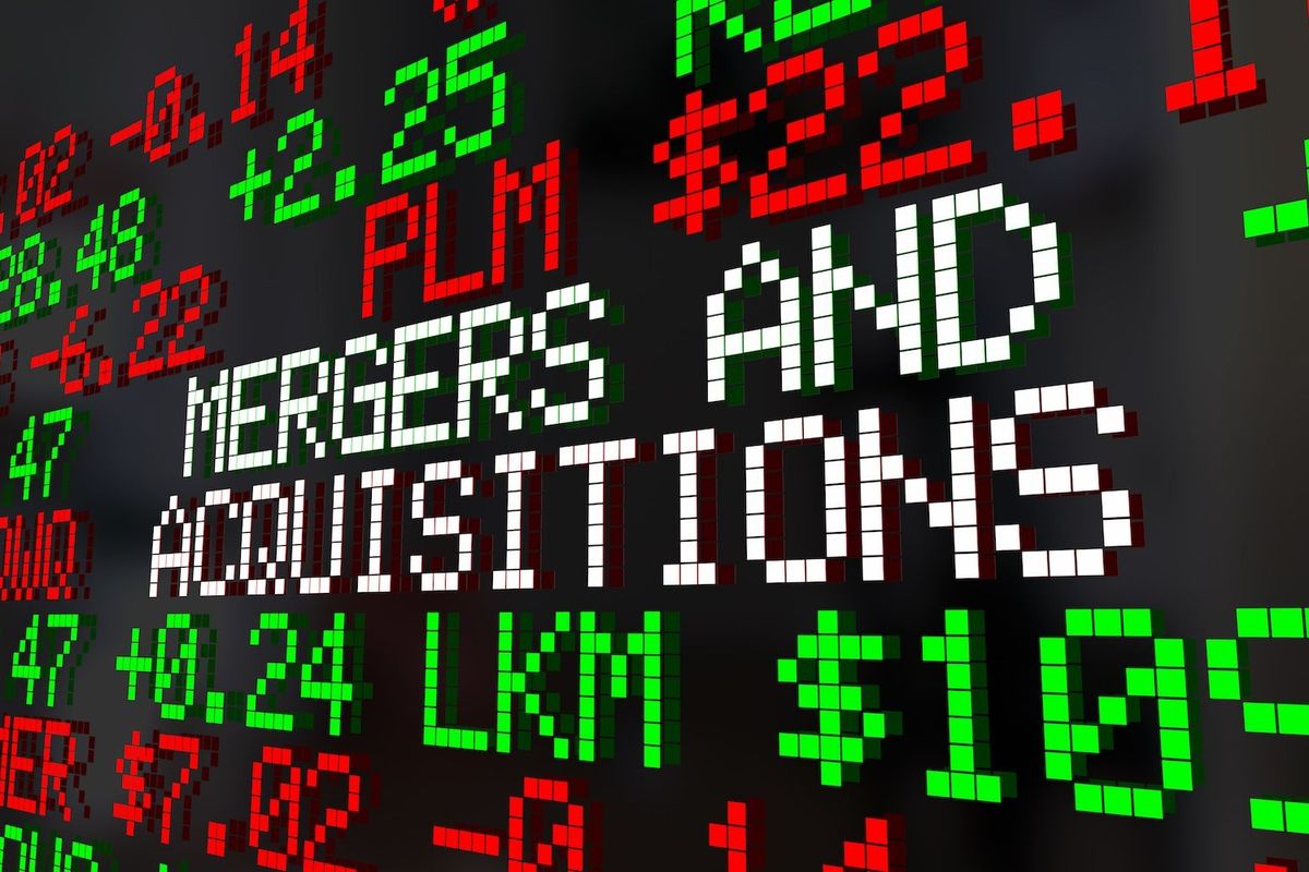 "Mergers and acquisitions" written on a stock ticker board.