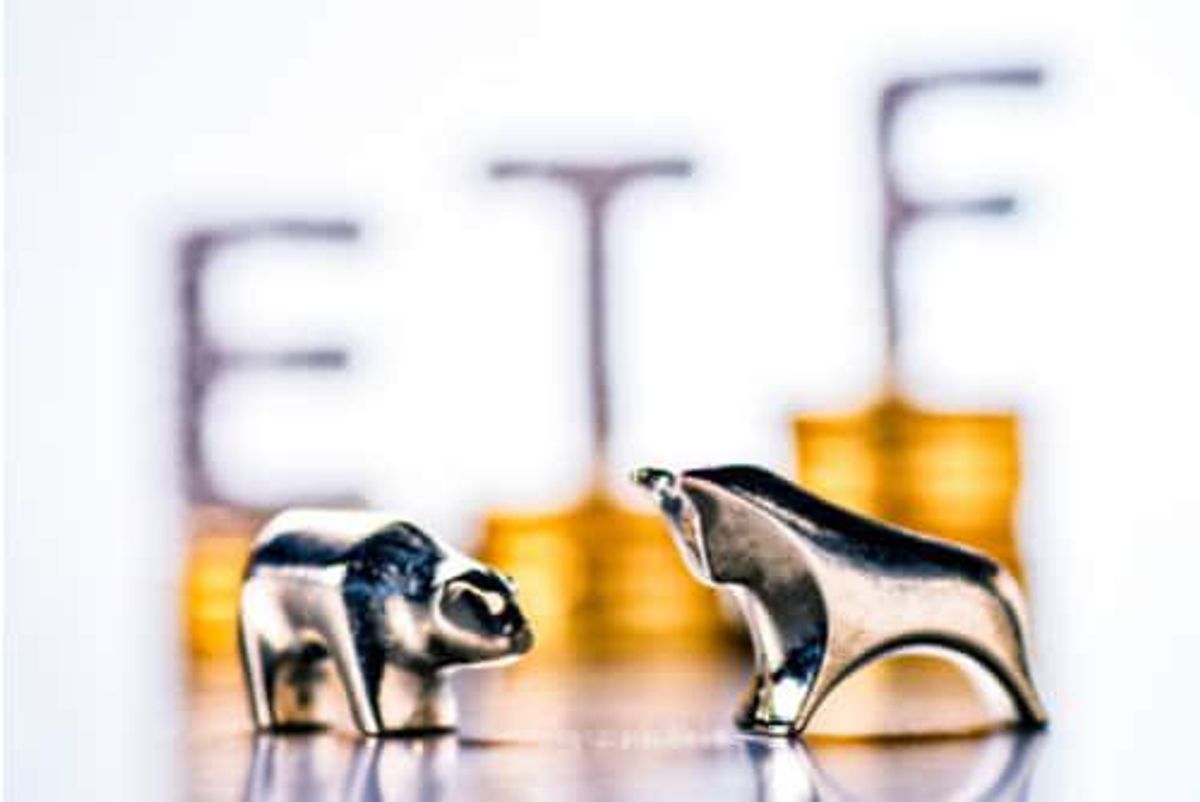 metal bull and bear figurines in the foreground with the letters "etf" in the background