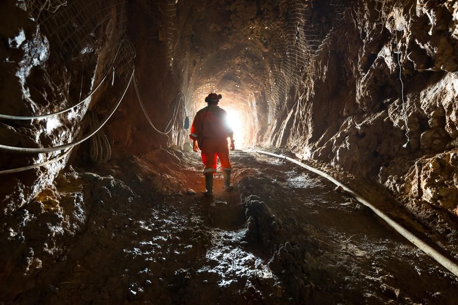 miner inside the access tunnel of an underground gold-copper mine