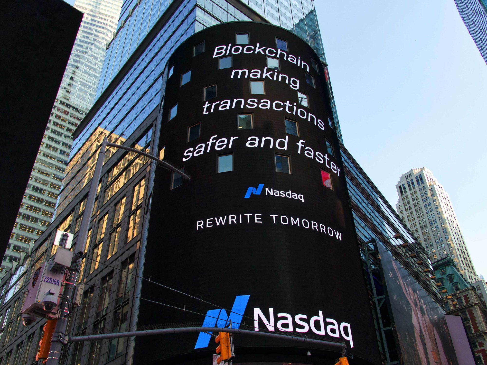 Nasdaq building display promoting blockchain for safer, faster transactions.
