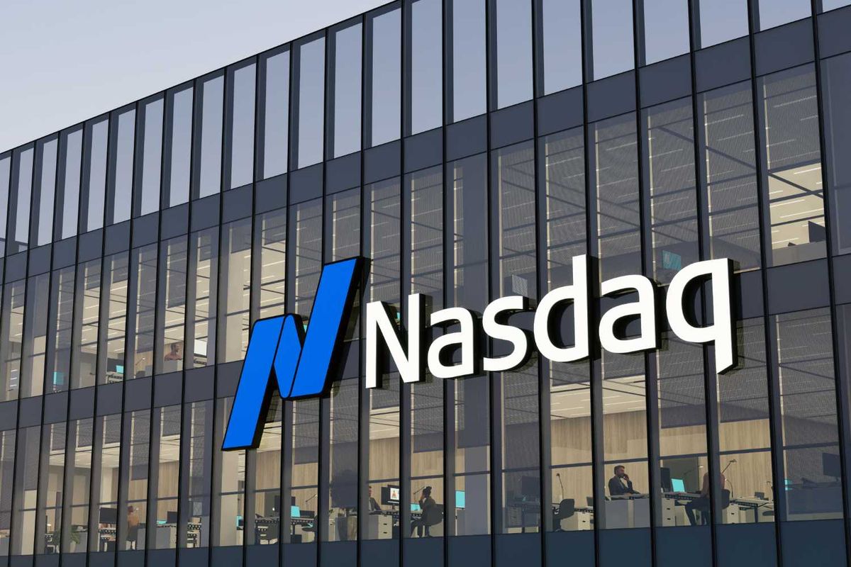 Nasdaq building facade with large logo and office interiors visible through glass windows.