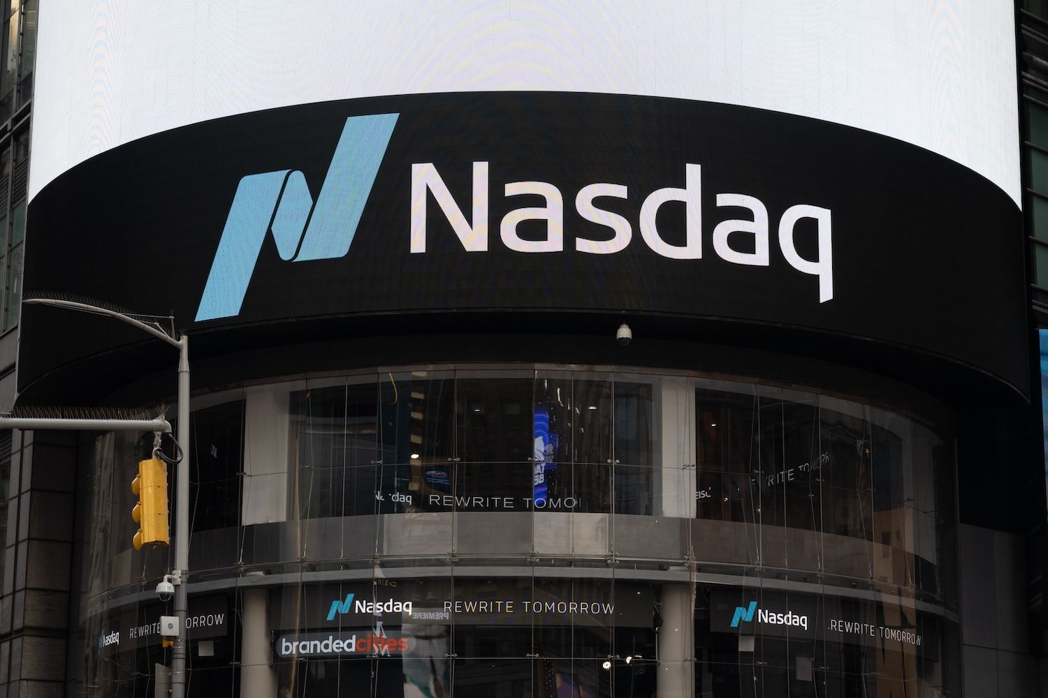 Nasdaq building with logo and screens in Times Square.