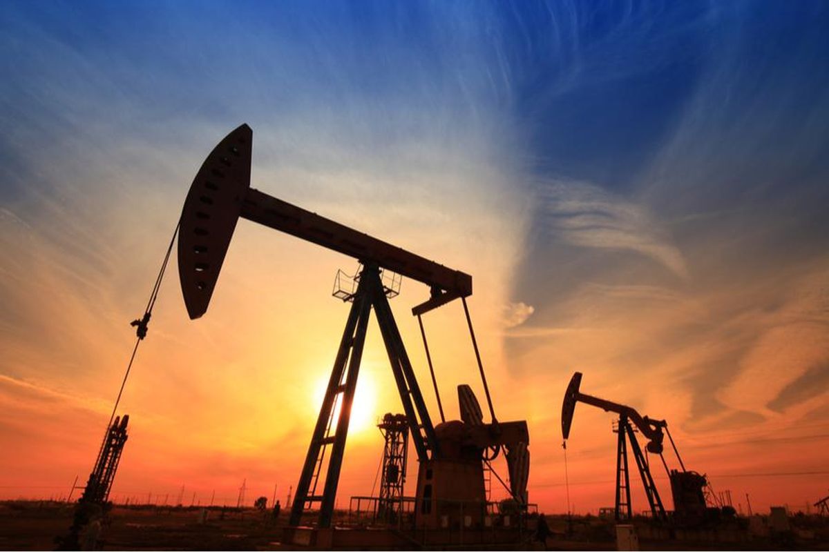 oil rigs on land in the sunset