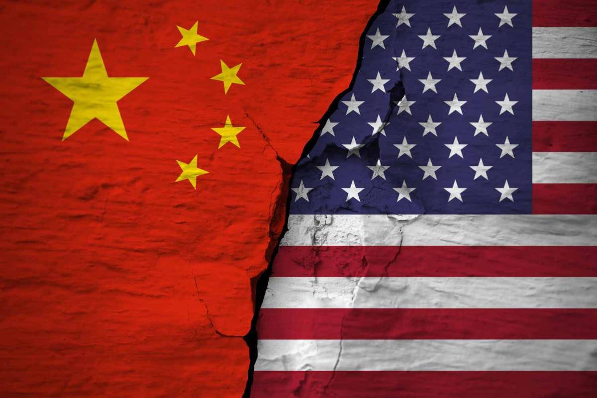 On a cracked surface, the flags of China and the US appear divided.