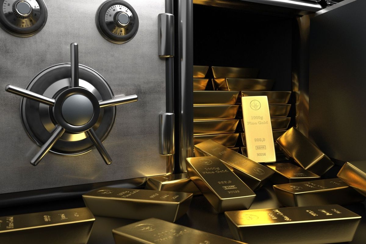 One kilogram gold bars spilling out of safe in central bank vault.
