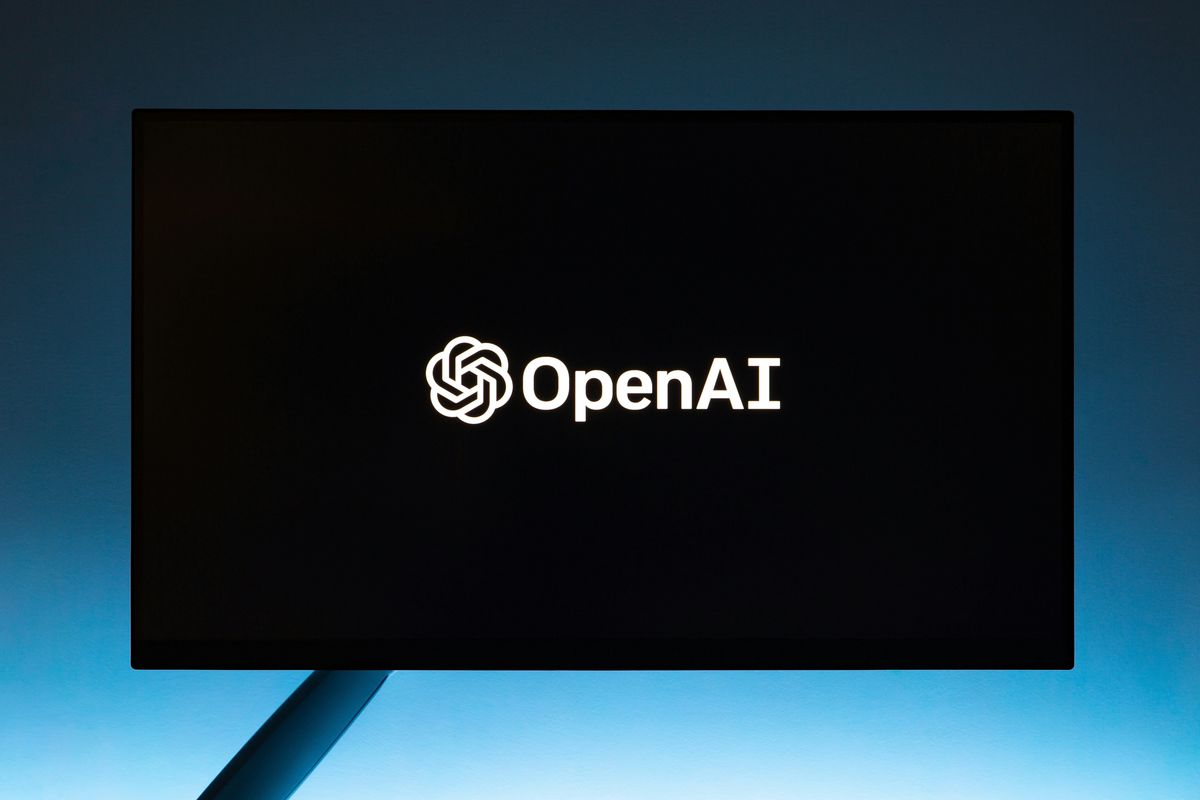 OpenAI logo on a dark screen with a soft blue gradient background.