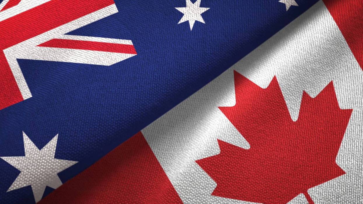 Overlapping Australian and Canadian flags on fabric.