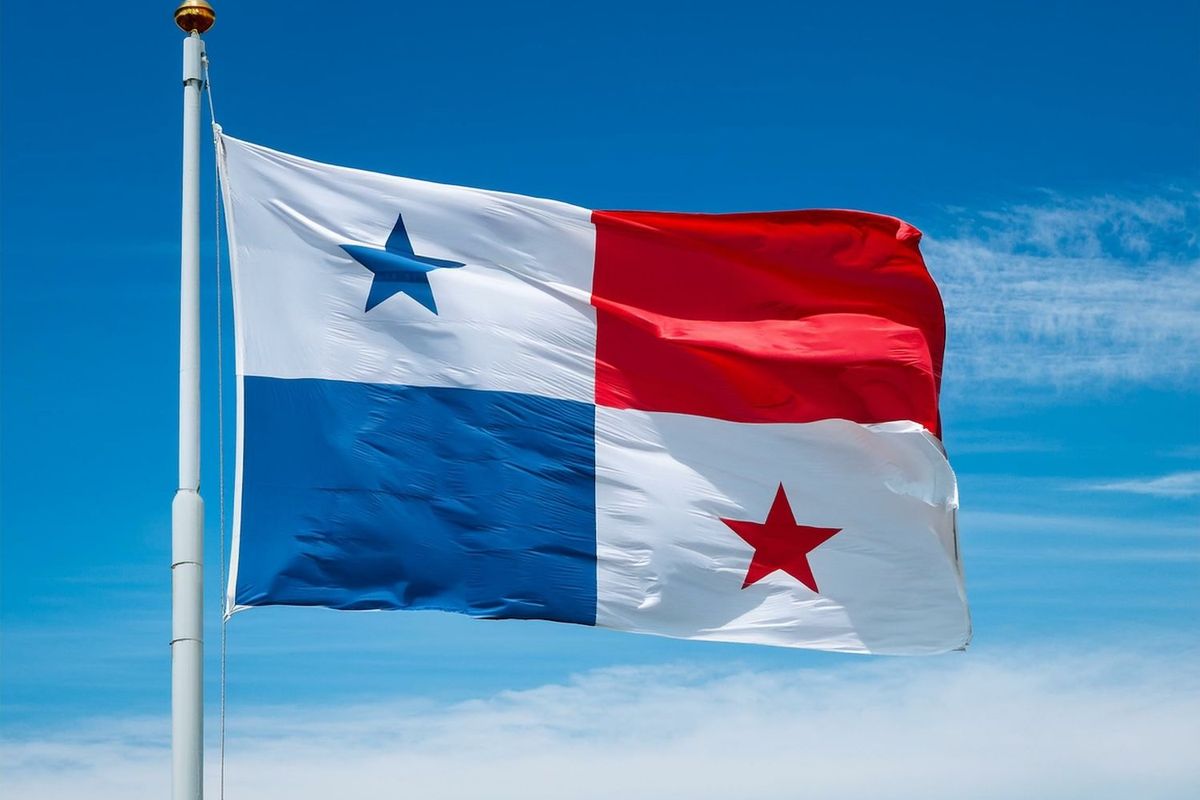 Panama flag waving against a clear blue sky.