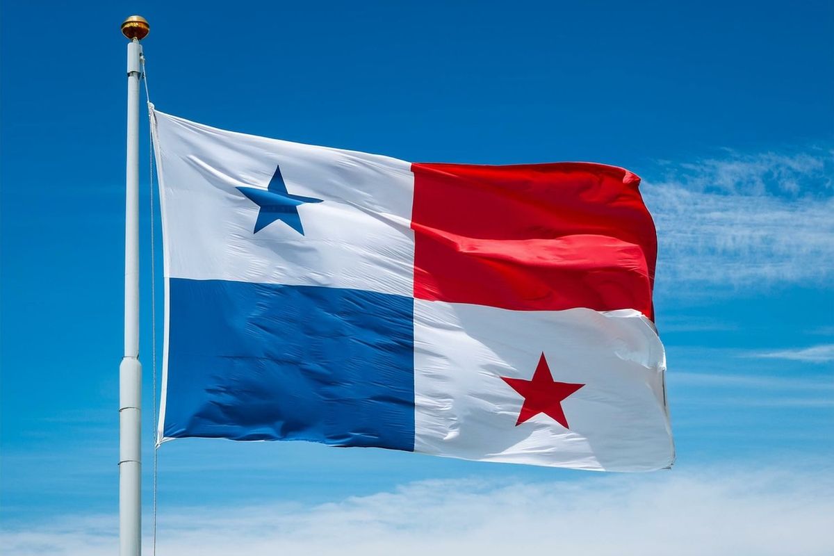 Panama flag waving against a clear blue sky.