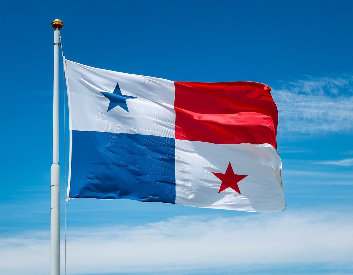 Panama flag waving against a clear blue sky.