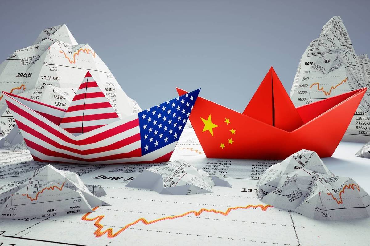 Paper boat with the American flag and another with the Chinese flag on financial charts background.