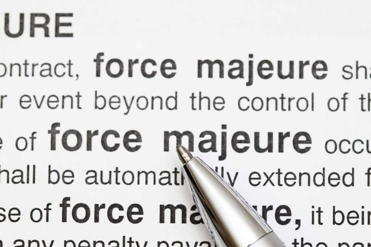 Pen pointing at "force majeure" in a legal document.