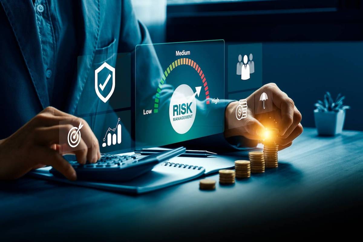 Person analyzing risk management data with calculator and digital graphics.