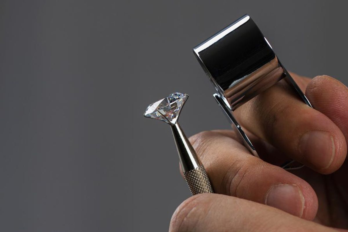 person examining diamond with loupe