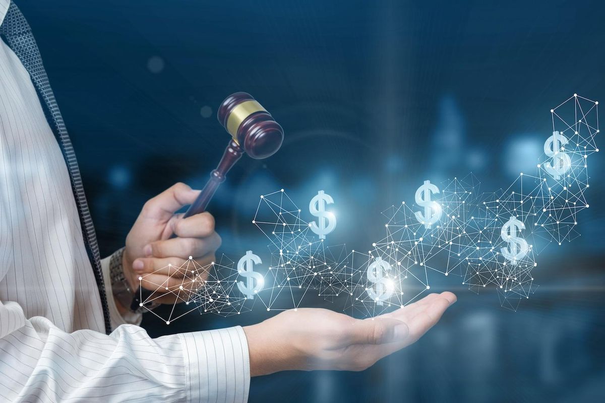 Person holding gavel and digital dollar symbols, symbolizing financial decision making.