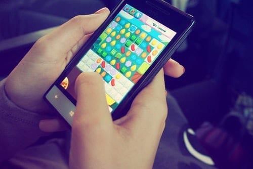 person holding phone with mobile game on screen