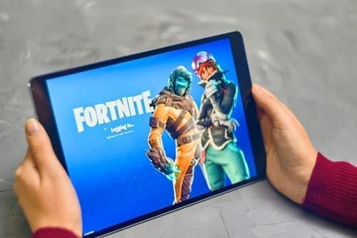 person holding tablet displaying Fortnite video game
