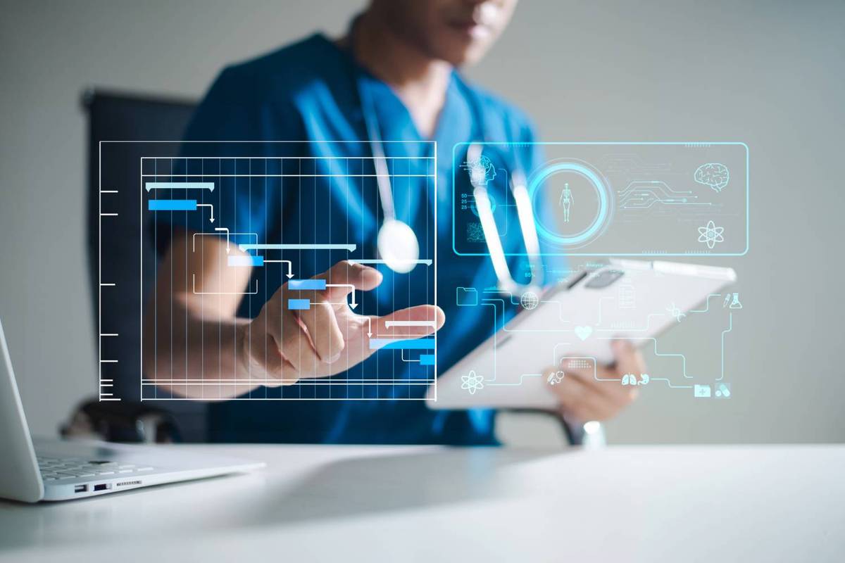 Person in blue scrubs interacts with a digital interface featuring graphs and medical icons.