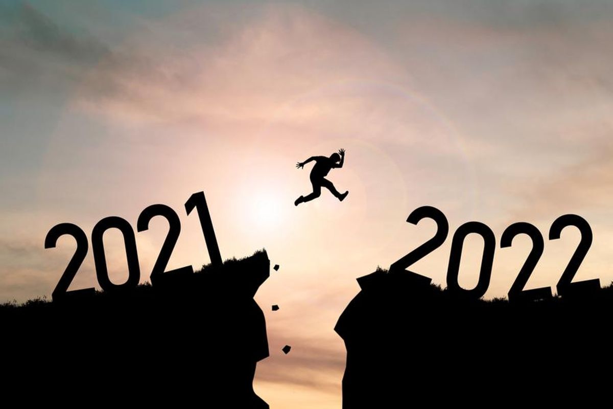 person leaping to 2022 over a crack in the earth