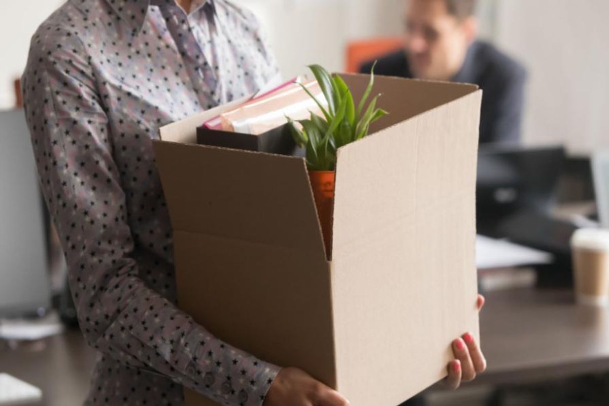 person leaving office with box of belongings