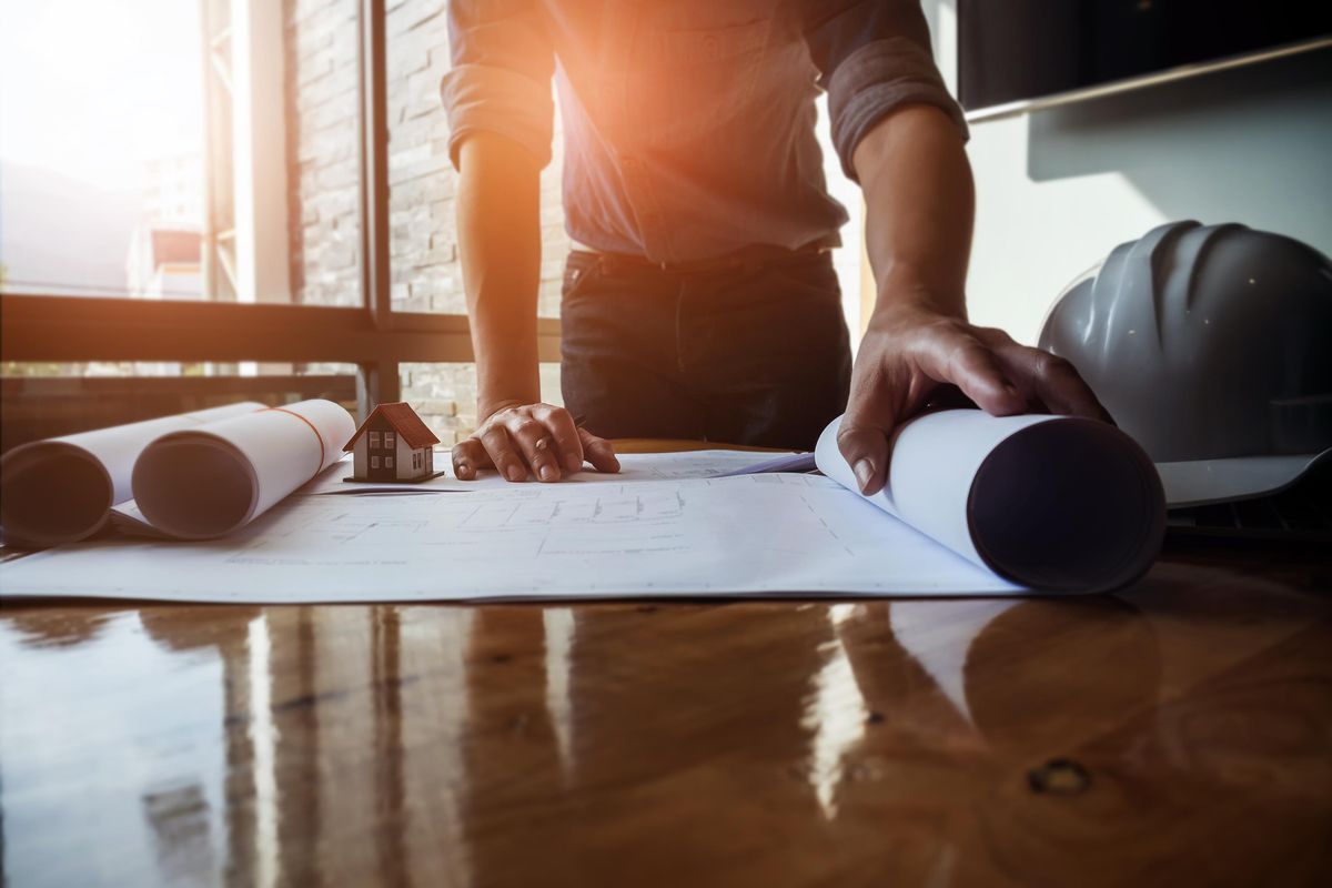 person looking at plans on a table