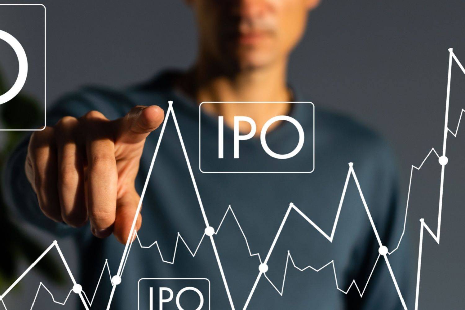 Person pointing at "IPO" text on a chart with fluctuating lines.