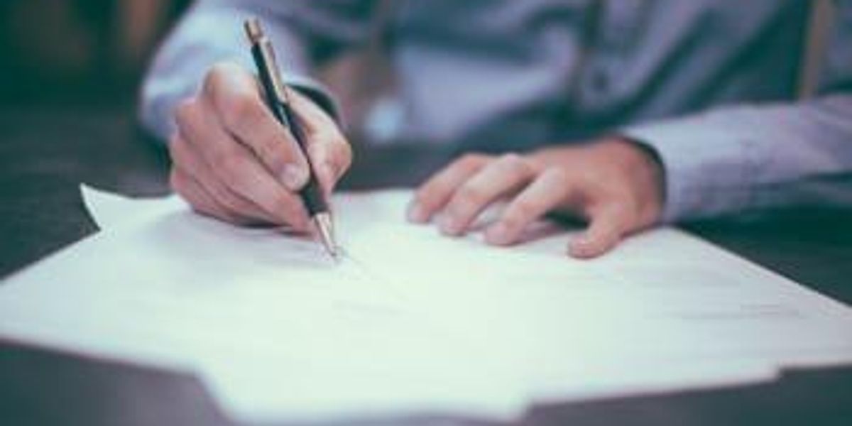 person signing a paper