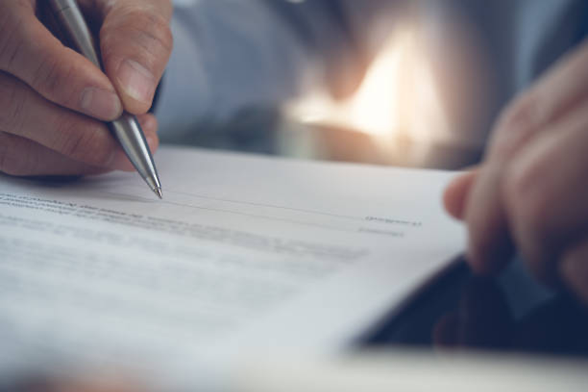 Person signing paper.