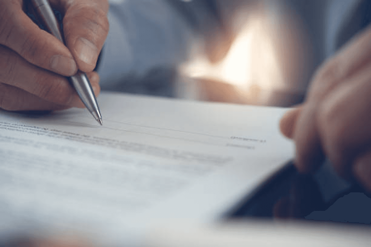 Person signing paper.