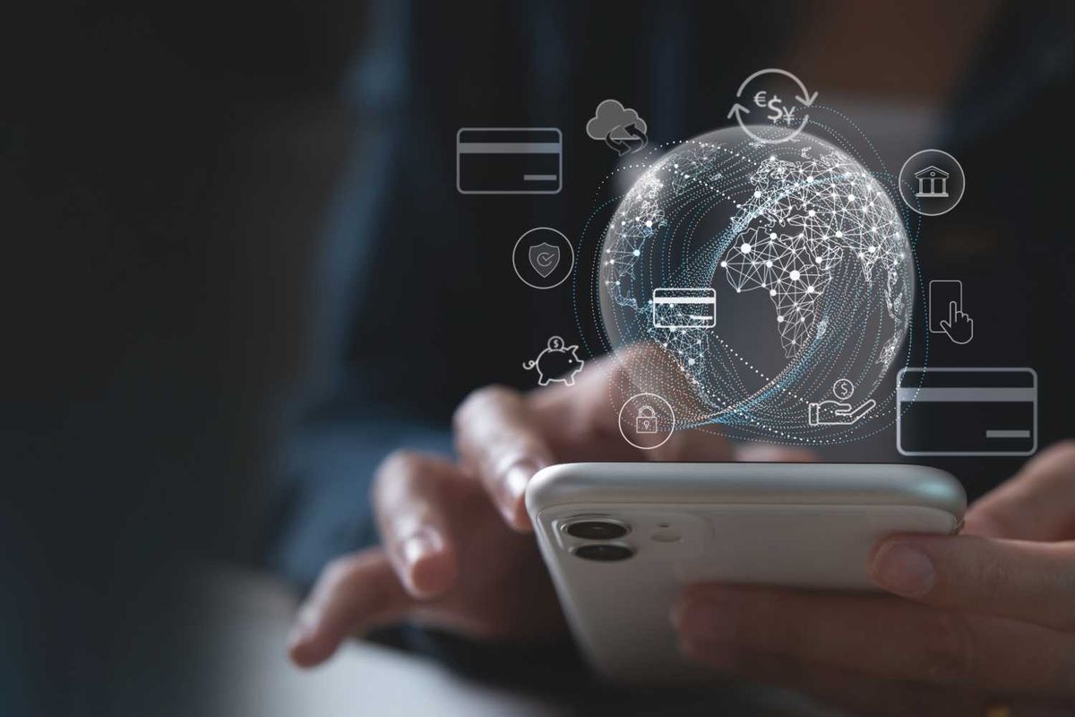 Person using smartphone with digital financial icons and globe overlay.