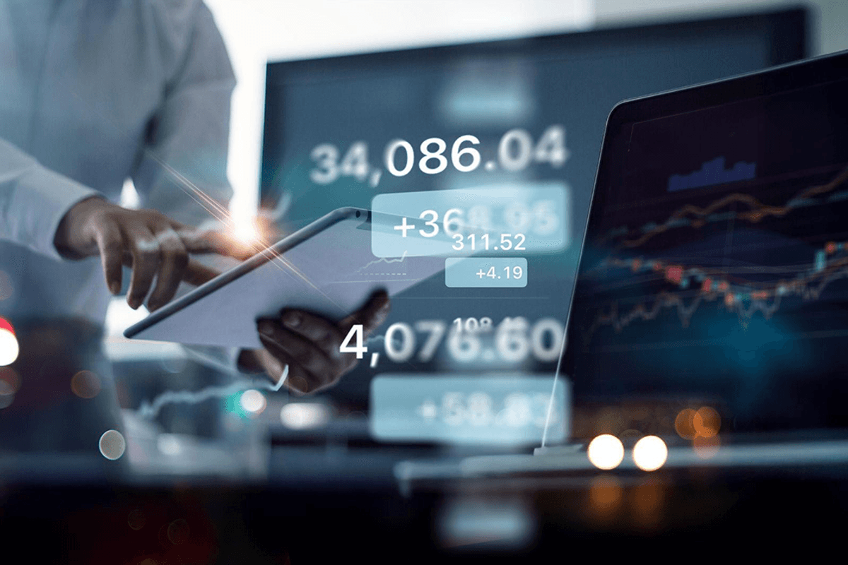Person using tablet with financial charts and numbers on screen.
