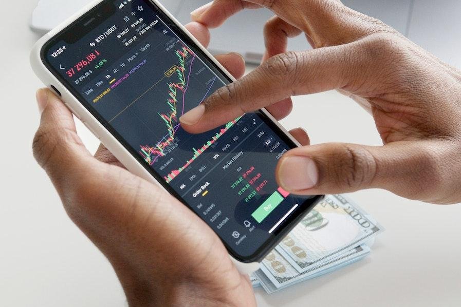 person using trading app on cellphone