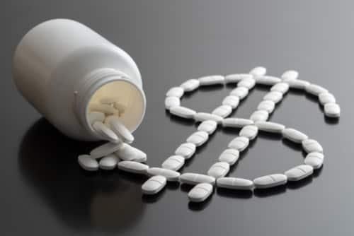 pharmaceutical pills spilling out of bottle to form a dollar sign