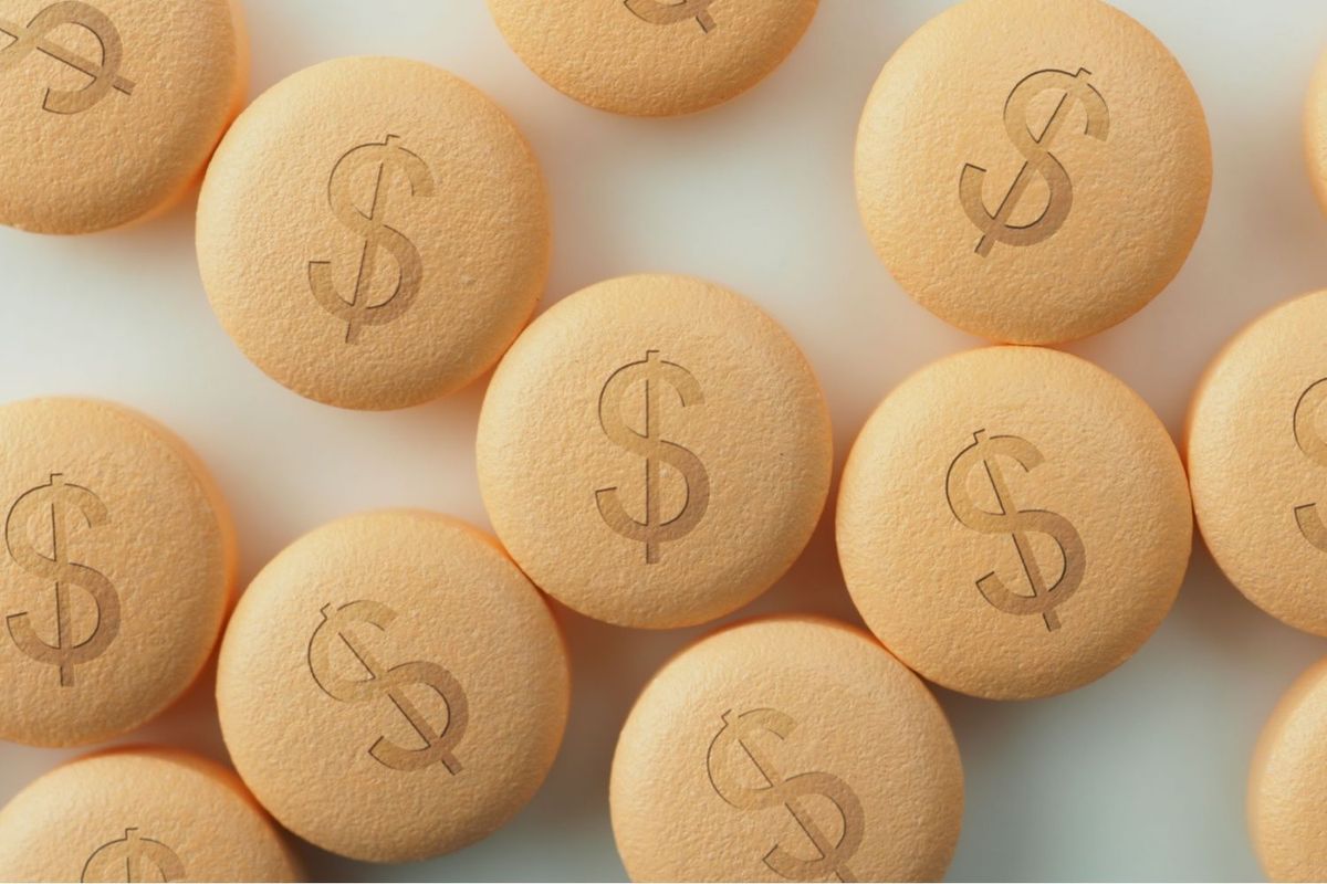 Pharmaceutical pills with dollar signs on them.