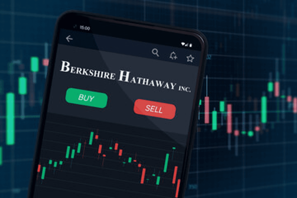 Phone screen showing "buy/sell" options for Berkshire Hathaway, with stock chart background.