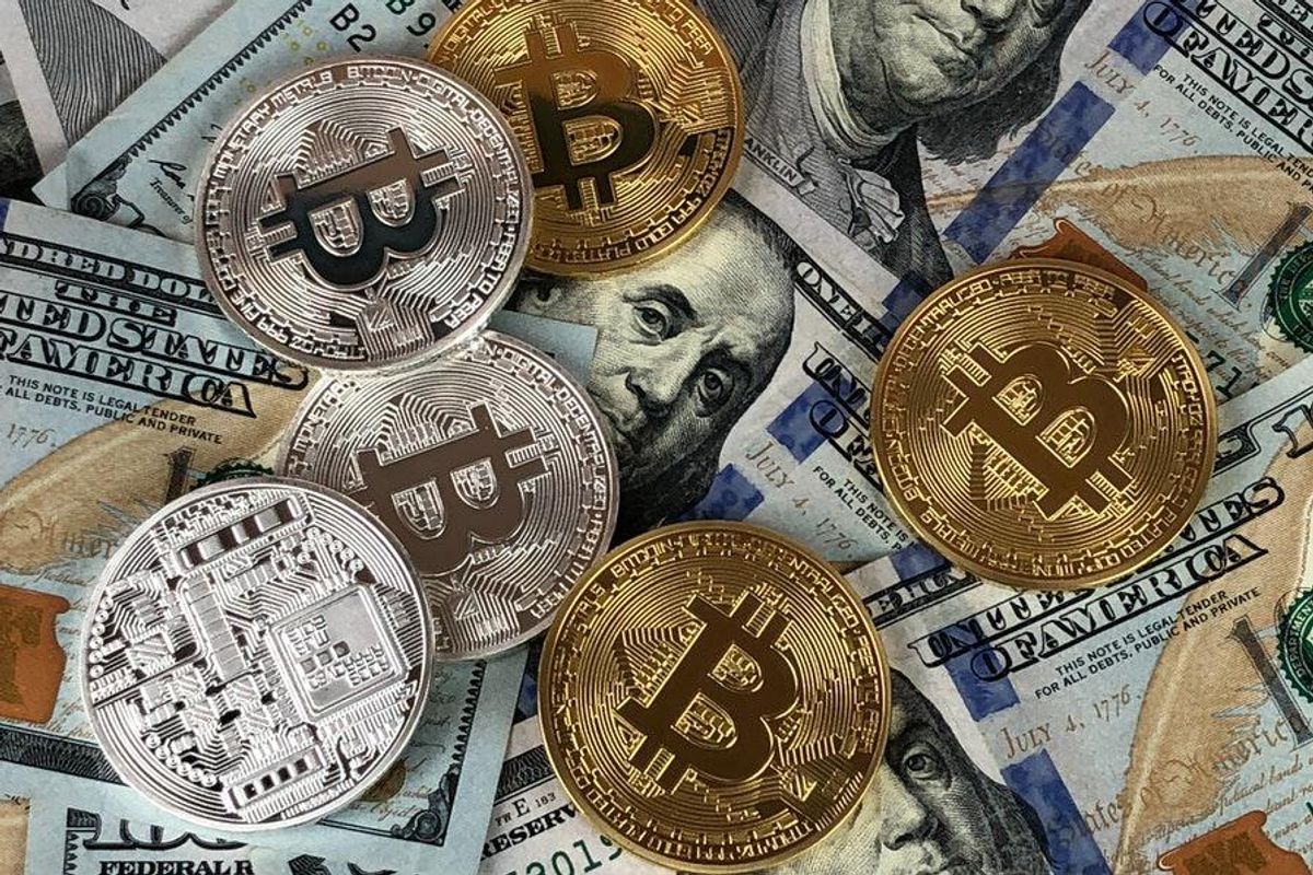 physical cryptocurrency coin representations laying on top of US dollars