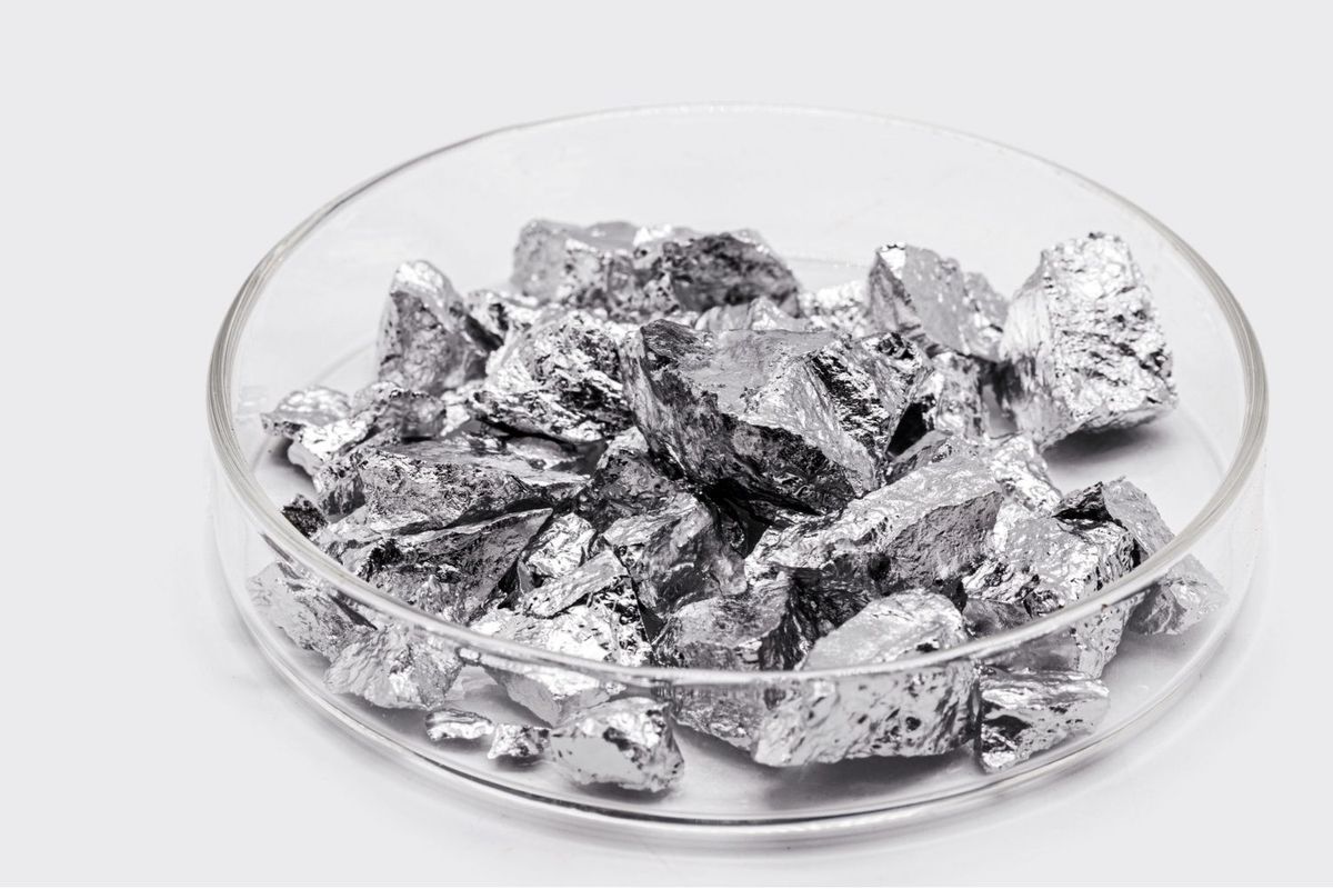 Pieces of refined aluminum in clear dish.