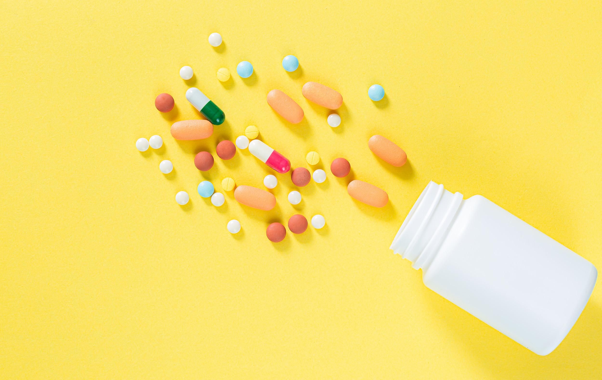 pills and pill bottles on yellow background