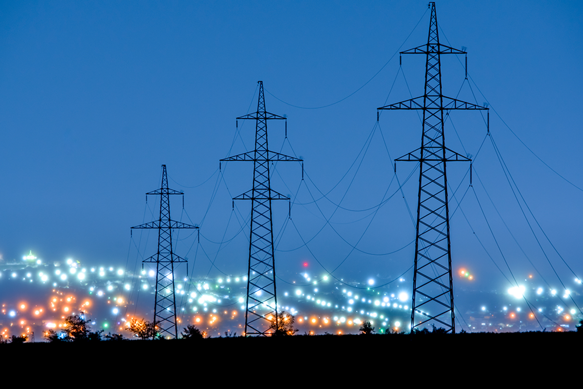 Power lines in the evening against a background of blurred city lights.