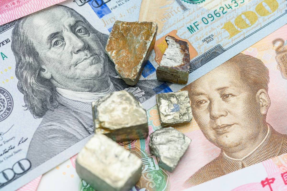Rare metal ores on US dollar and Chinese yuan bills.