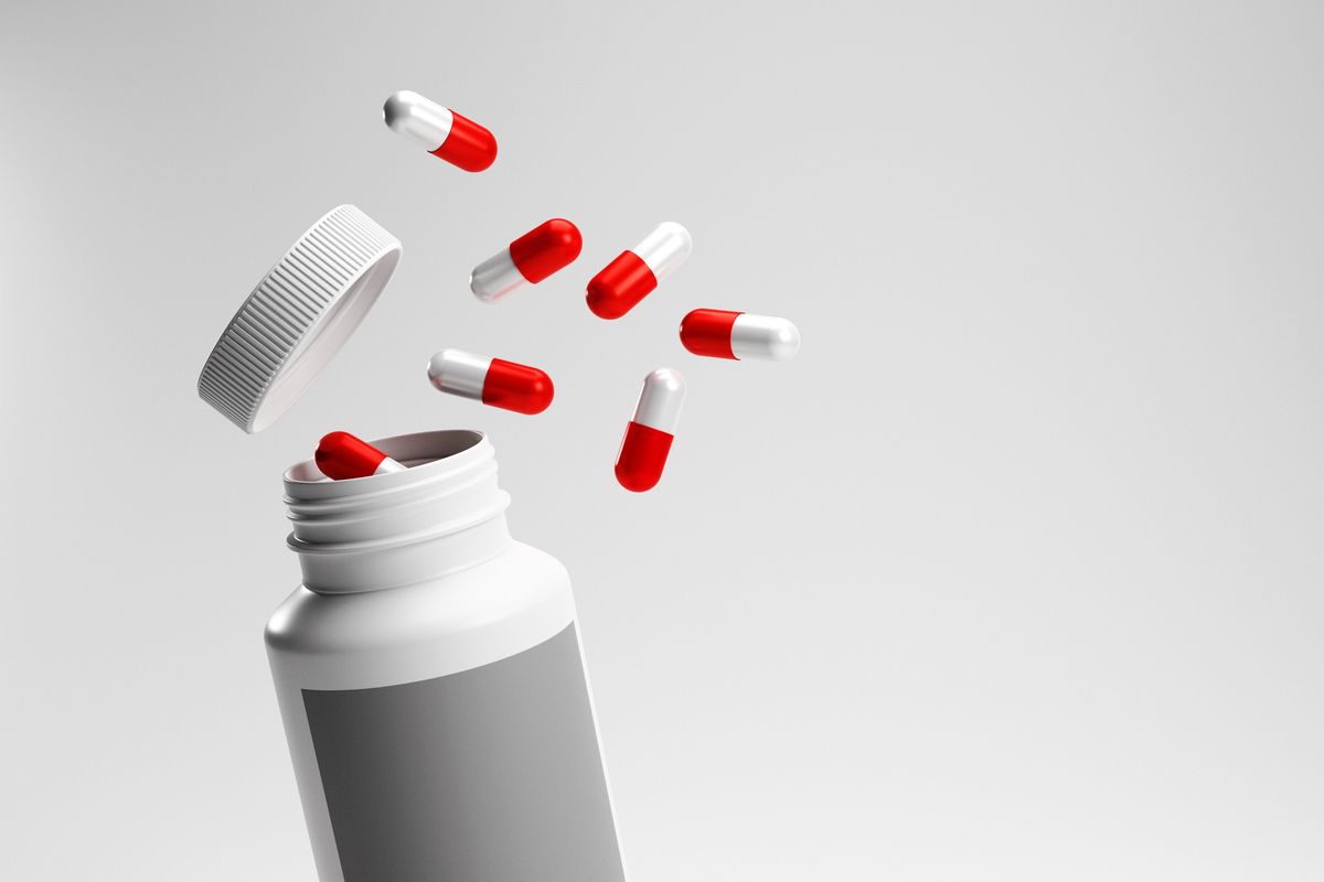 Red and white medical pills with bottle.