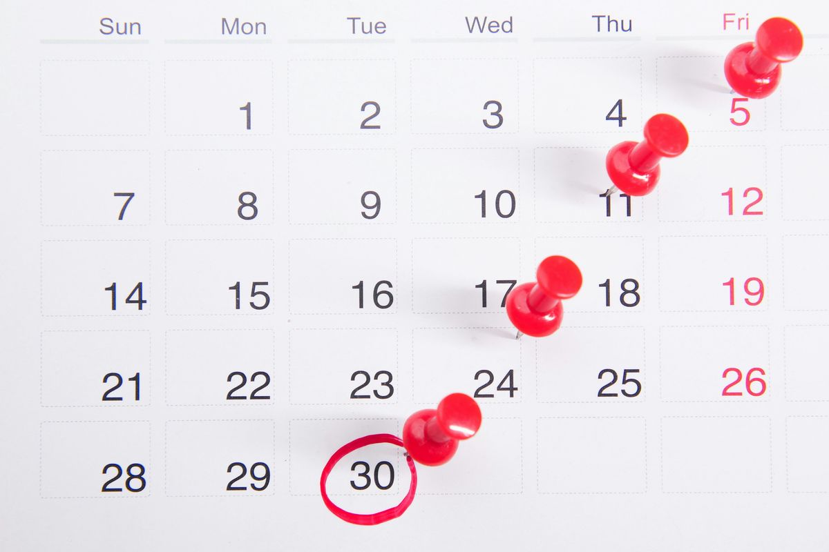 Red push pins in calendar.
