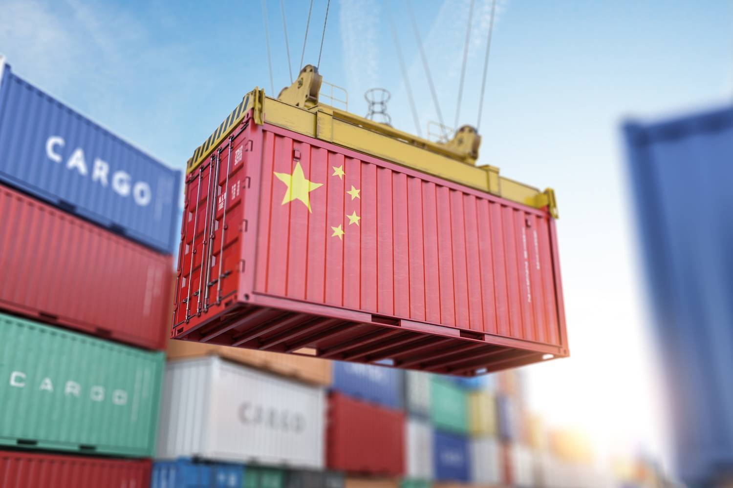 Red shipping container with Chinese flag being lifted by a crane.