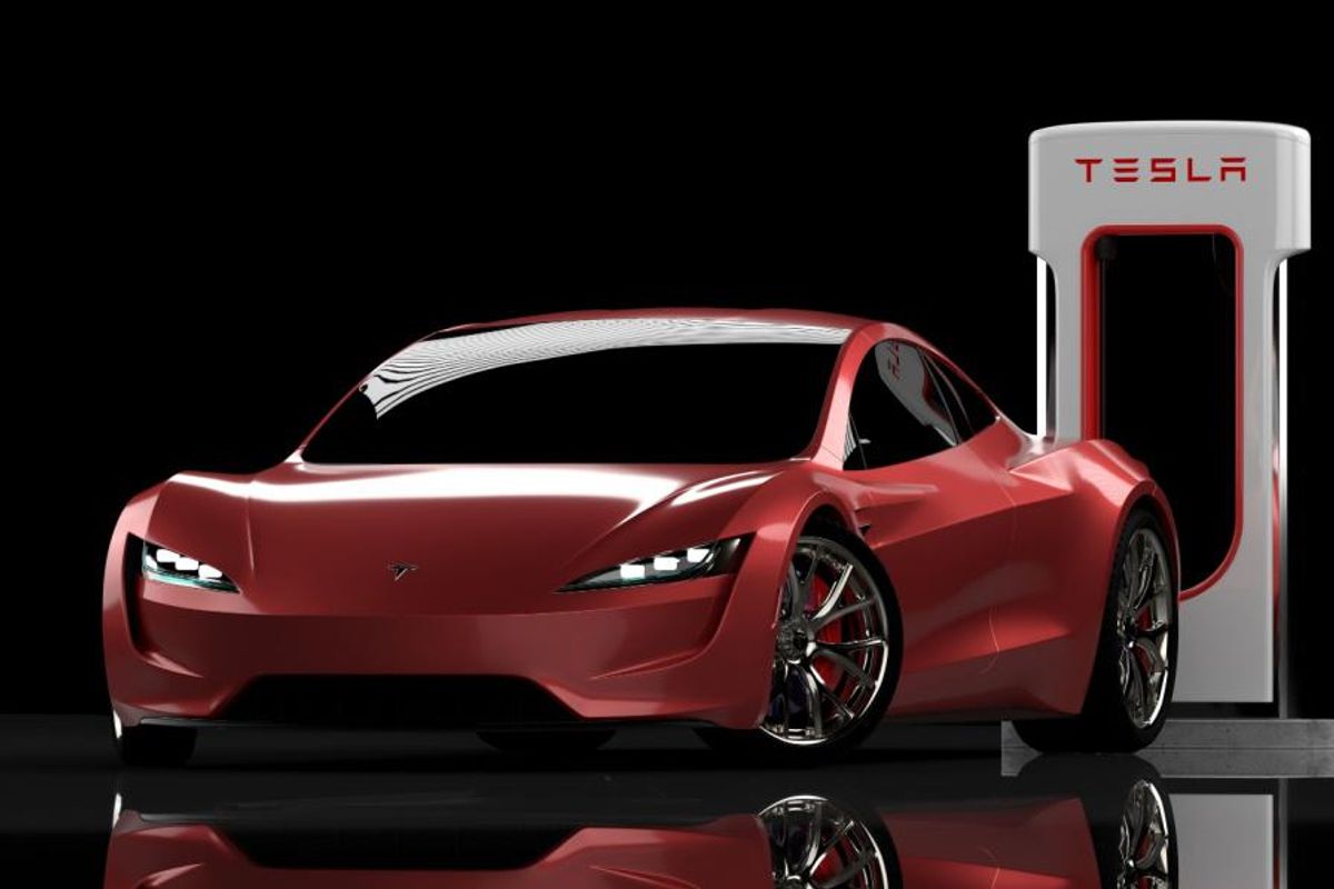 red tesla car in front of a charging station