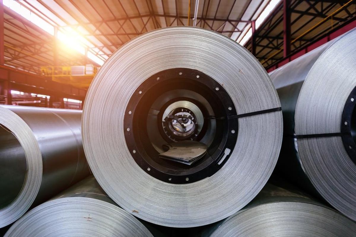 Rolls of galvanized steel sheet inside a factory or warehouse.