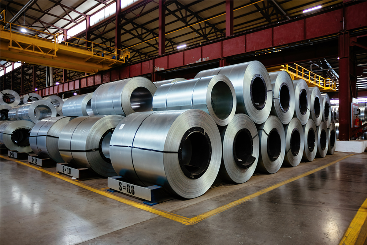 Rolls of galvanized steel sheets inside a warehouse.