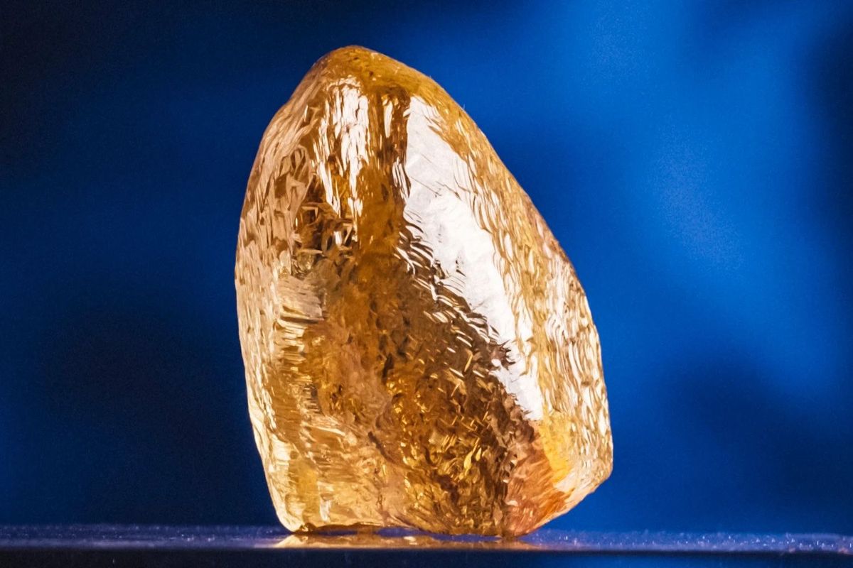 Rough, yellow diamond against a blue background.