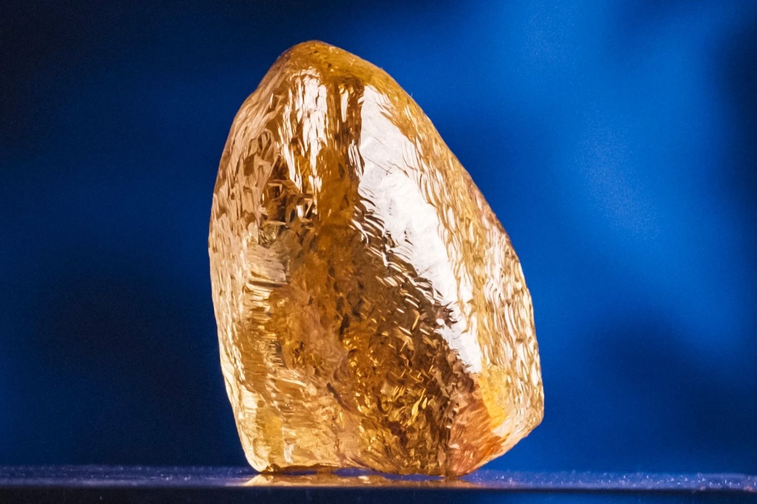 Rough, yellow diamond against a blue background.