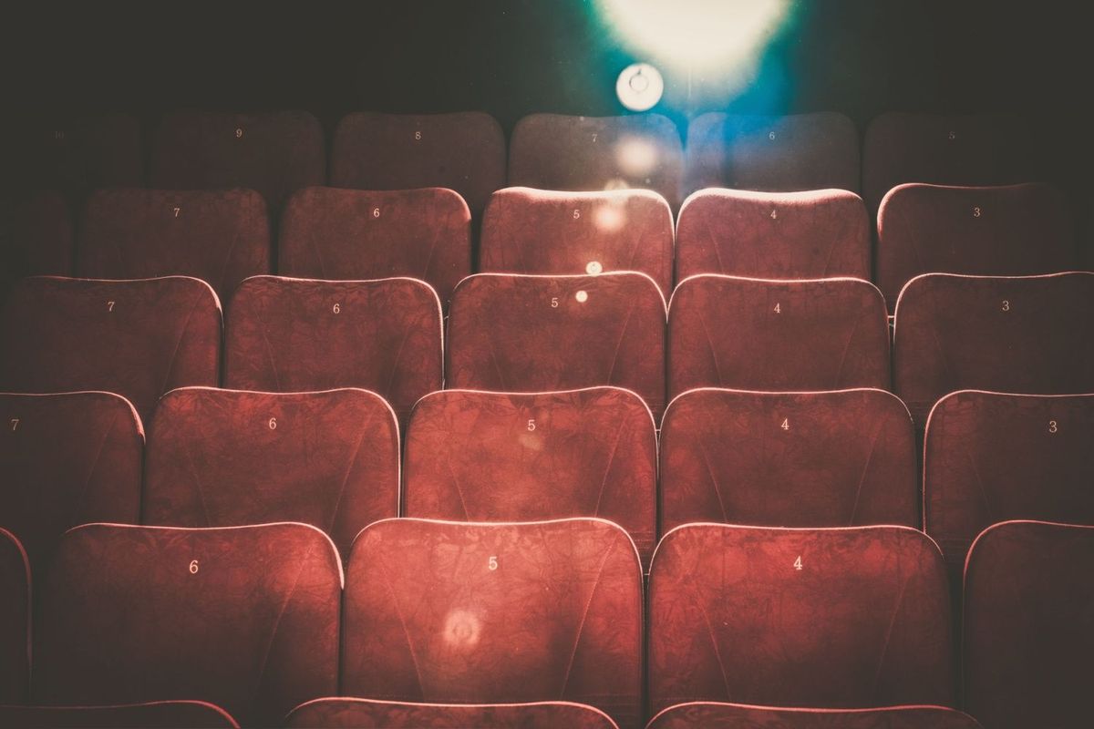 Rows of red movie theatre seats with numbers on them.
