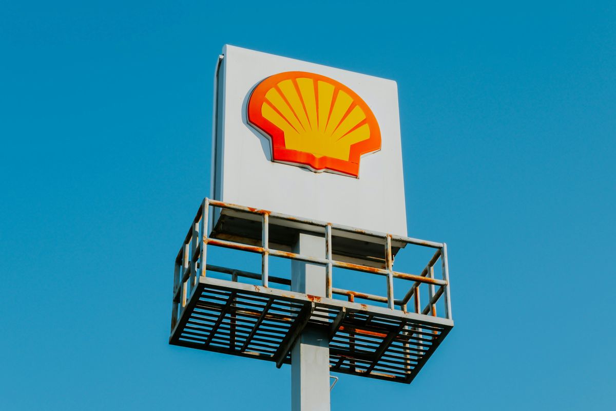 Shell sign on a tall pole against a clear blue sky.